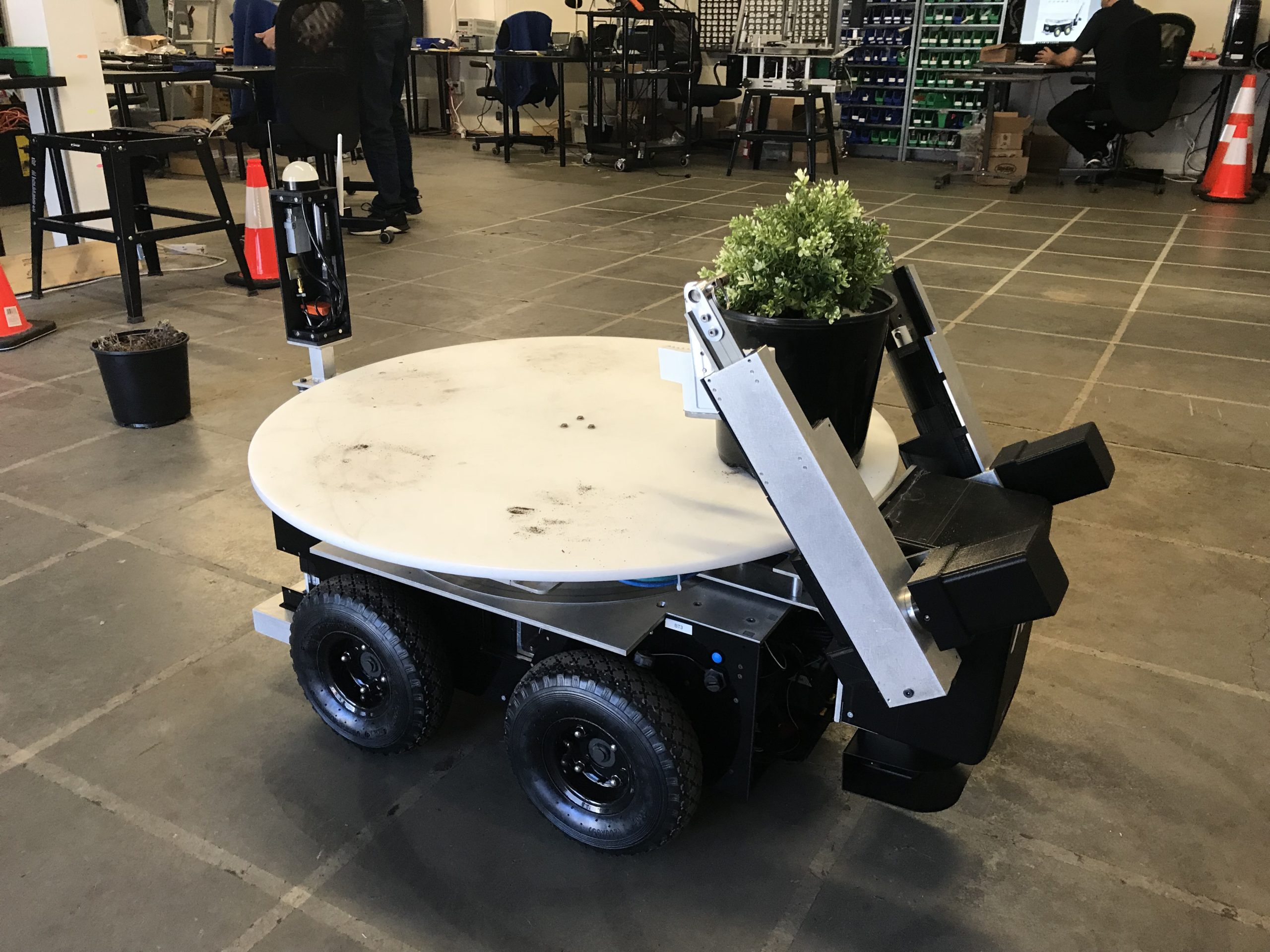BigTop autonomous mobile robot holding a plant in a plant nursery.