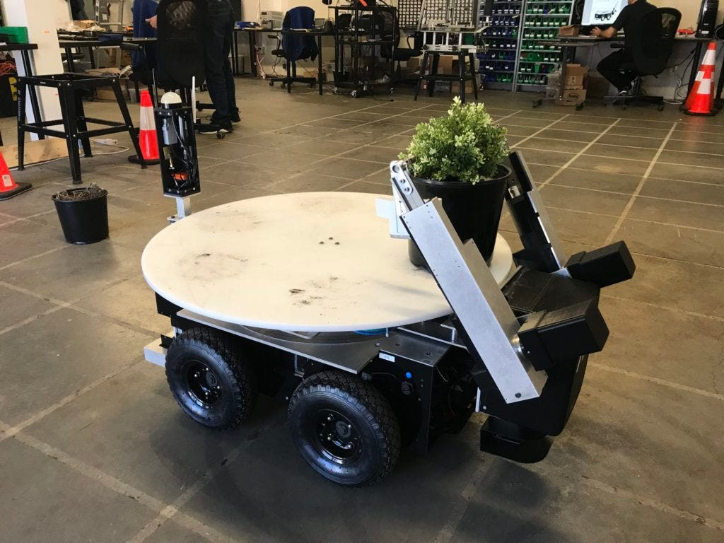 AIS robot lifting a potted plant.