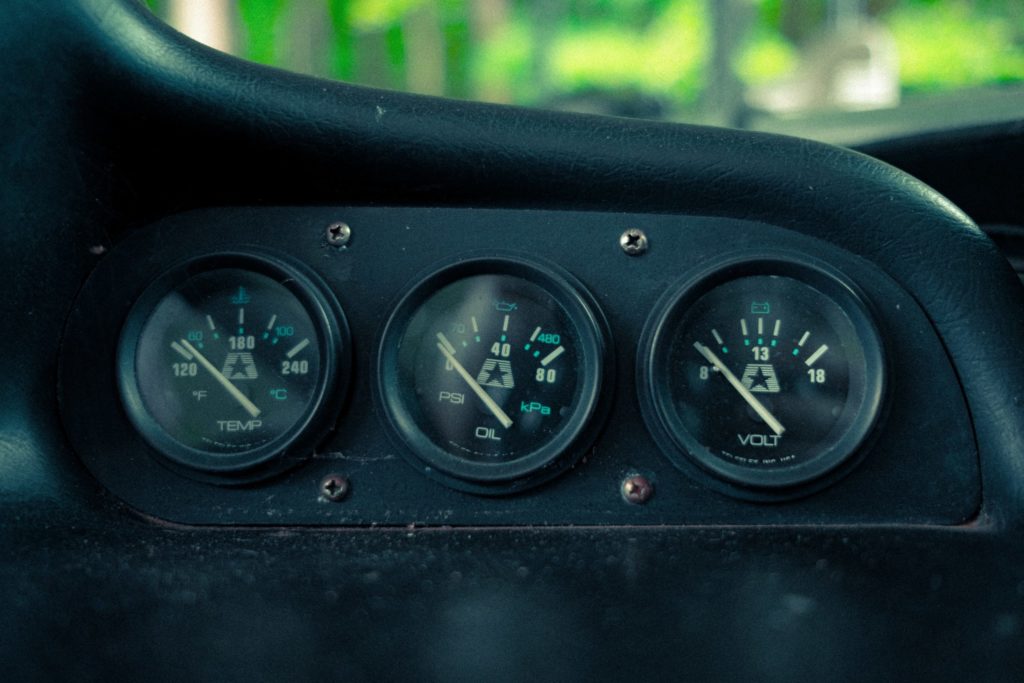 Close up of vintage instrument cluster with three gauges.