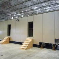 Side view of valid modular RCMP holding cell trailer with steps leading up to the doors.