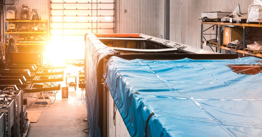 Wood chip trailer being fitted with auto tarp system.